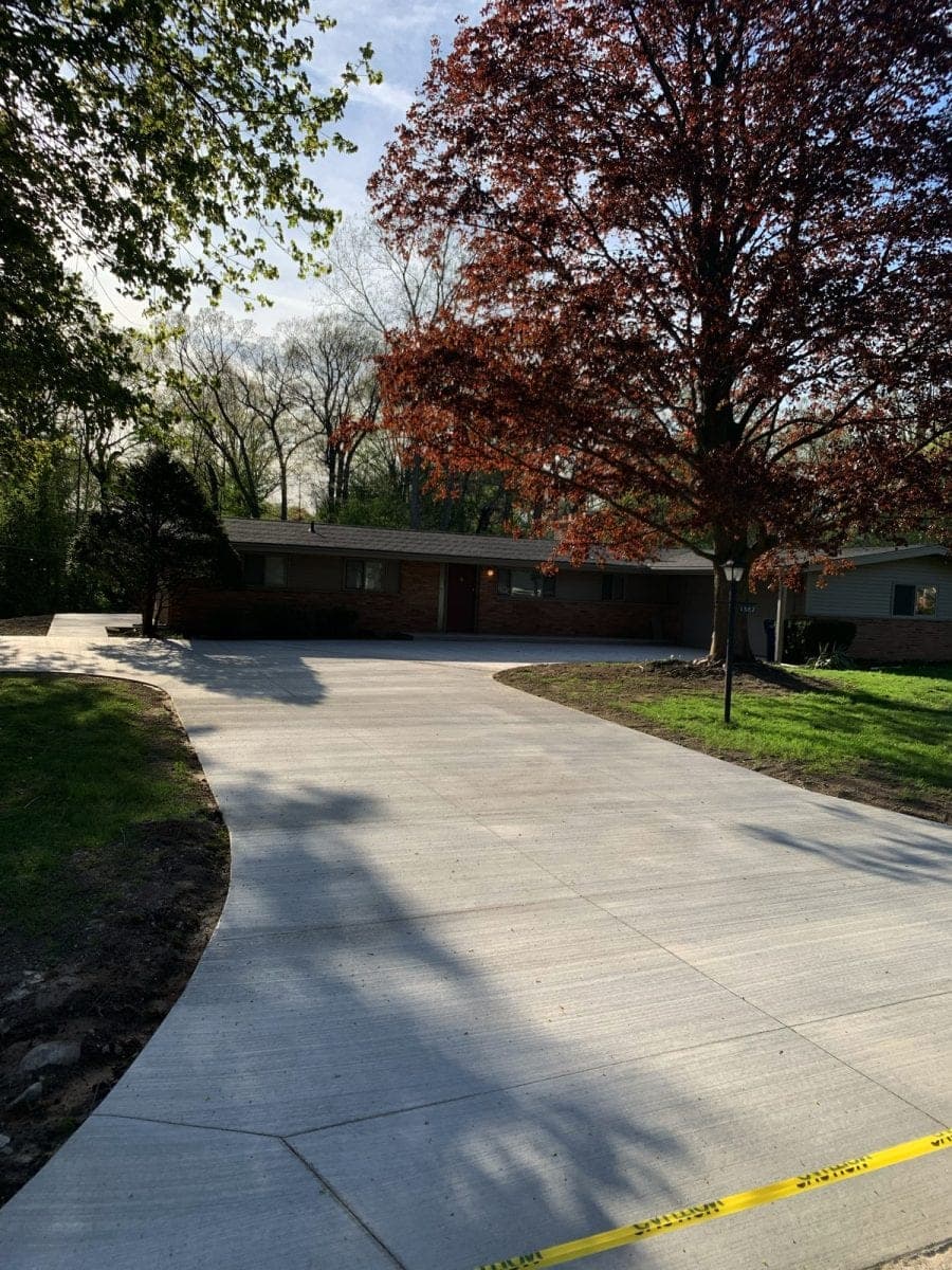 Homeowner in Southwestern Ontario inspecting a driveway for cracks in autumn before winter sealing