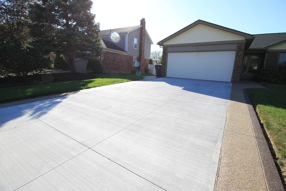Exposed aggregate concrete driveway leading to a garage