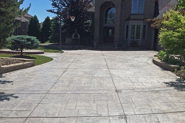 Weathered stamped concrete driveway before sealing
