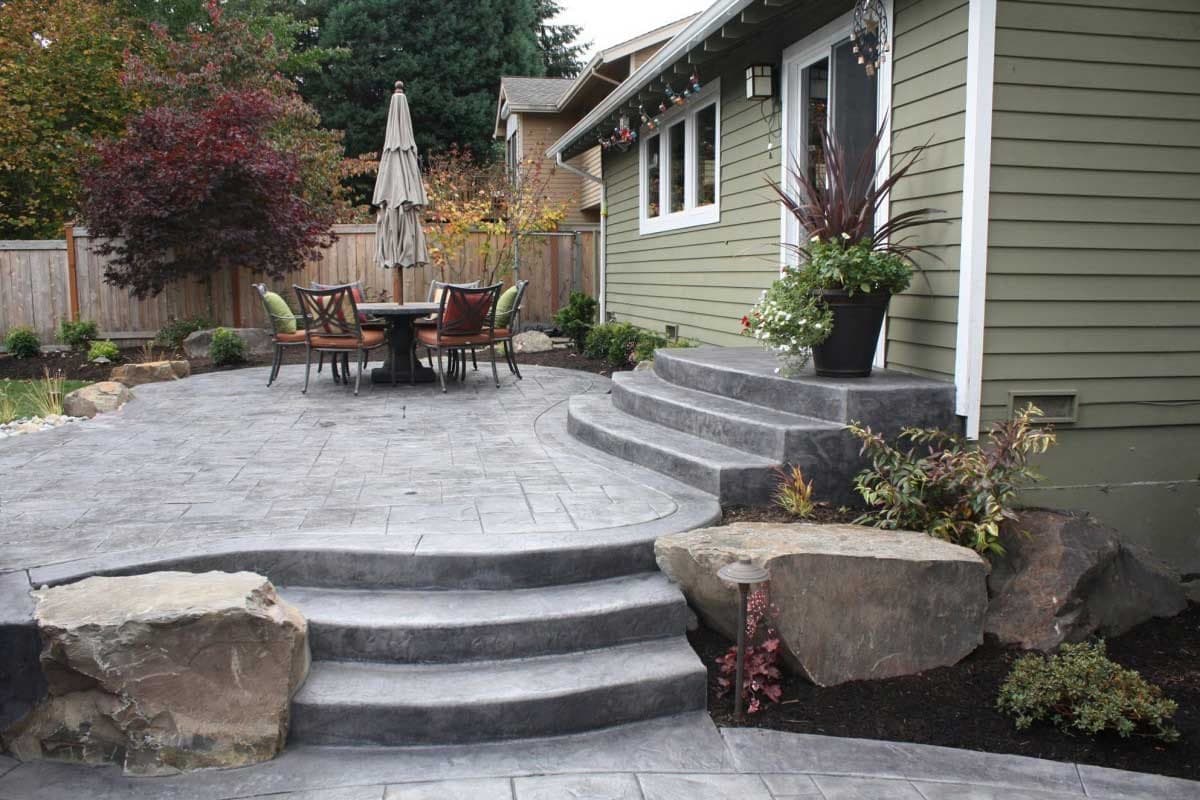 Stamped concrete patio with steps and landscape boulders
